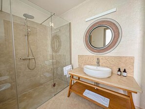 A modern bathroom with a glass shower enclosure, a round mirror, and a wooden vanity with a sink. - The Blue Room at Riad Timija: En-suite, Breakfast & Rooftop in the Medina (Marrakesh)