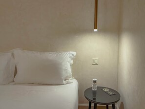 A hotel room with a bed, a bedside table with a phone, and a light fixture on the wall. - The Double Room at Riad Timija: En-suite, Breakfast & Rooftop in the Medina (Marrakesh)