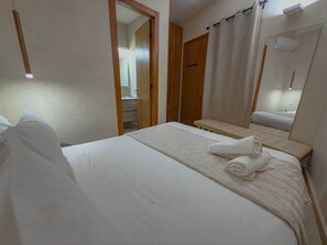 A hotel room with a bed, a bathroom visible through an open door, and a mirror reflecting part of the room. - The Double Room at Riad Timija: En-suite, Breakfast & Rooftop in the Medina (Marrakesh)