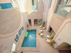 A rooftop pool area with a small pool, lounge chairs, and potted plants. - The Red Room at Riad Timija: En-suite, Breakfast & Rooftop in the Medina (Marrakesh)