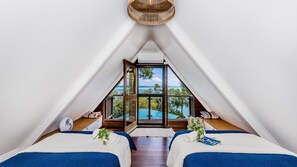 A bedroom with two beds, a view of the sea, and a ceiling fan. - Riverbank 1770  waterfront (Seventeen Seventy)