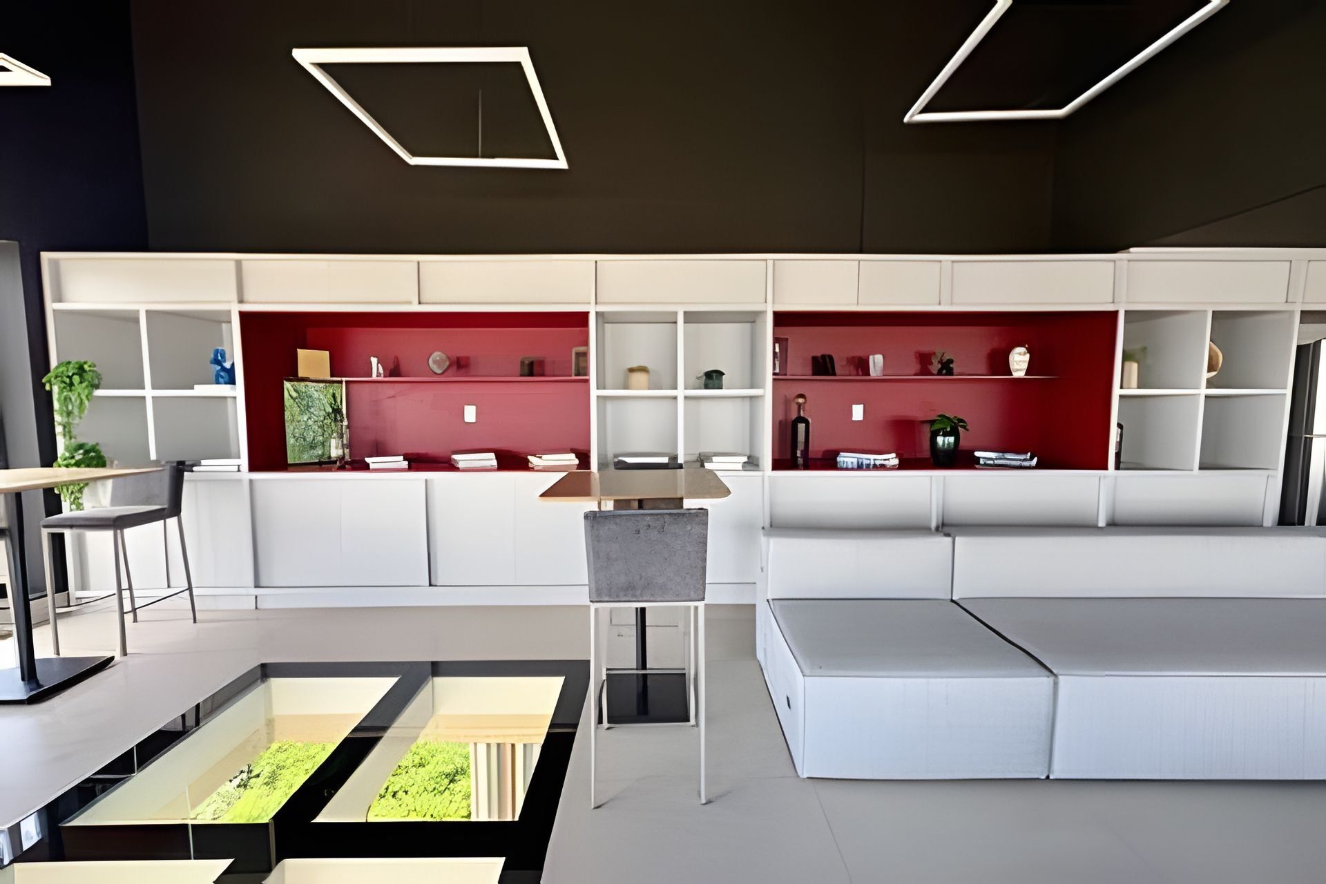 Un intérieur moderne avec un canapé blanc, une table à manger et un mur d’accent rouge.
