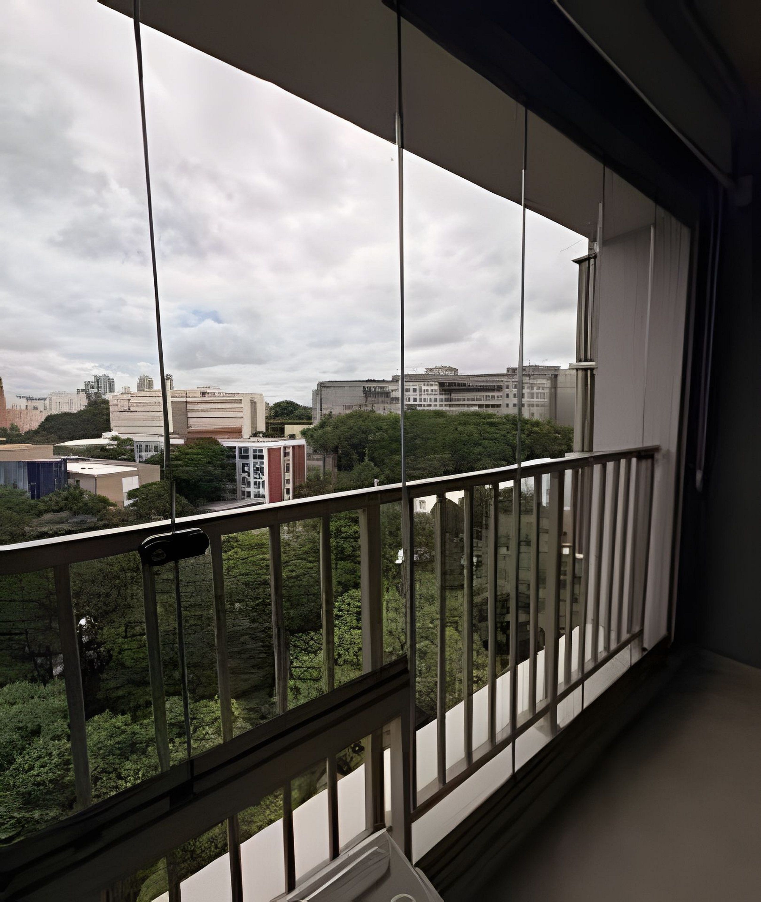 A balcony with a view of buildings and trees.