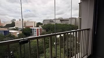 A balcony with a view of buildings and trees.