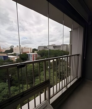 A balcony with a view of buildings and trees. - On Melo Alves (São Paulo)