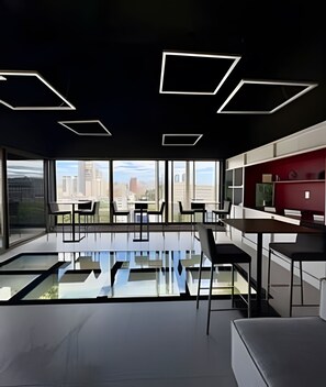 Un interior moderno con piso de vidrio, ventanas amplias y vista a la ciudad.