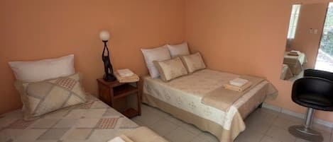 A room with two beds, a nightstand, a chair, and a ceiling with a unique pattern.