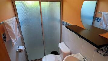 Ein Badezimmer mit Toilette, Waschbecken und Duschbereich.