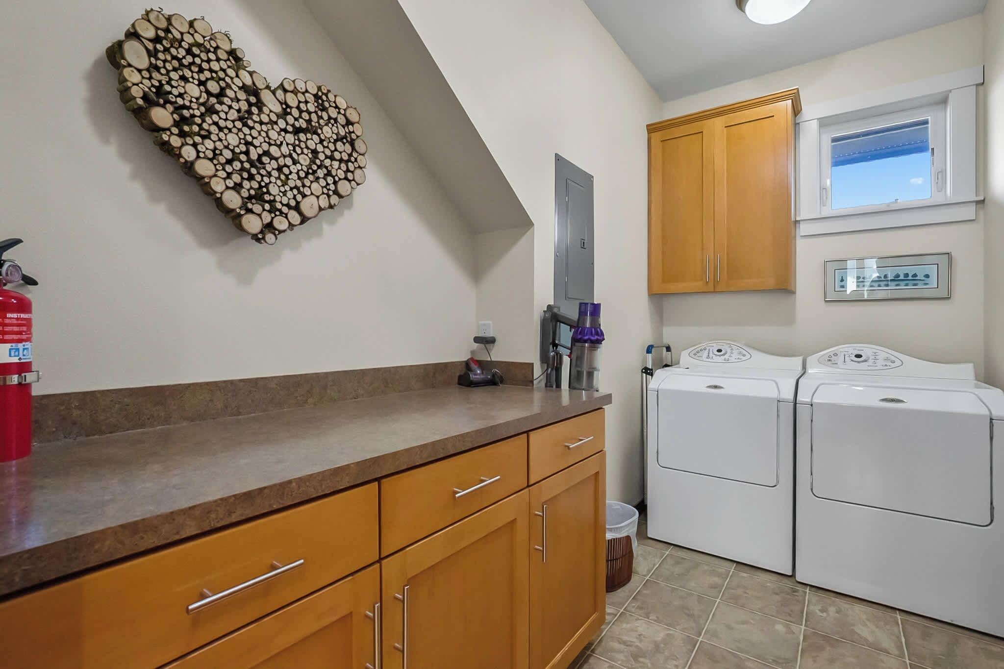 A laundry room with a washing machine, a dryer, and a fire extinguisher.