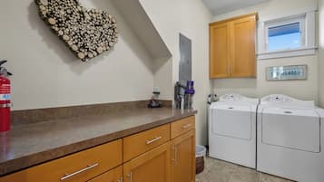 A laundry room with a washing machine, a dryer, and a fire extinguisher.