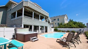 A two-story house with a backyard featuring a swimming pool, lounge chairs, and a hot tub. - Oceanside-Priv Pool, Htub, Resort Access -133, I SEA the Light (Corolla)