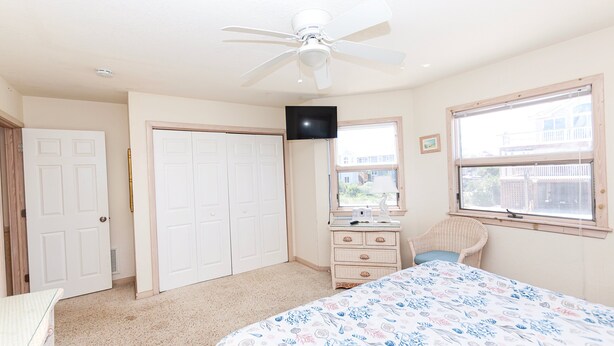 A bedroom with a bed, a dresser, a television, and a window. - OCEANFRONT, Ocean views, Dogs Welcome, Hot Tub- CP24, ROAR by the Shore (Corolla)