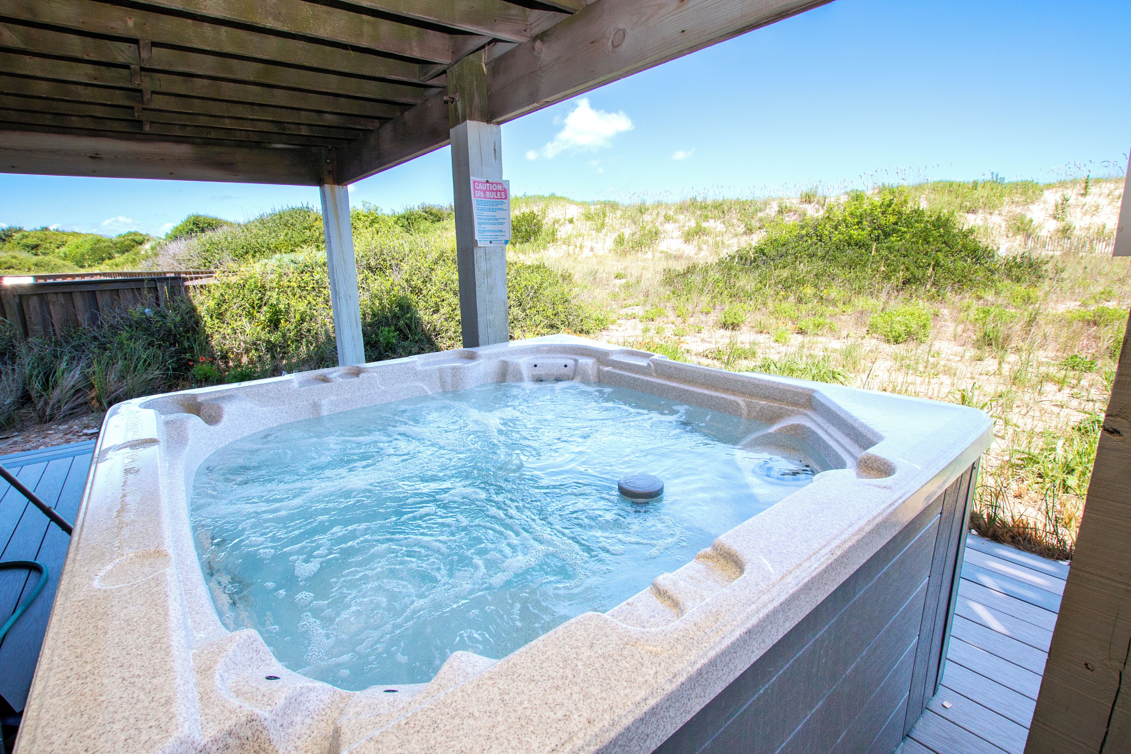 Un jacuzzi con cubierta de madera y un cartel que indica las normas del spa.