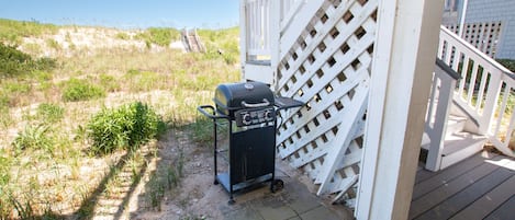 Un área de terraza con una parrilla y una valla de madera.