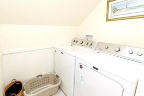 A laundry room with two Maytag washers and dryers, a wicker laundry basket, and a framed picture on the wall. - OCEANFRONT, Ocean views, Dogs Welcome, Hot Tub- CP24, ROAR by the Shore (Corolla)