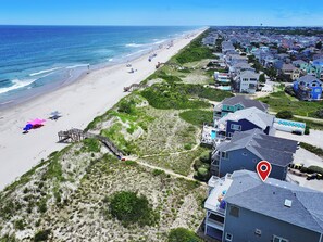 Un quartier résidentiel situé sur la côte, avec accès à la plage, des maisons et une jetée.