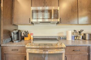 A kitchen with stainless steel appliances, including a microwave, oven, and coffee maker. - 2 Cabins - Indoor Pool & 2 Hot Tubs - Sleeps 13 (Pigeon Forge)