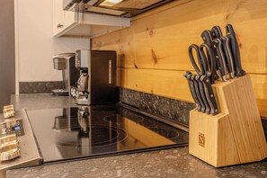 A kitchen with a wooden countertop, a coffee maker, a stove, and a knife block. - 2 Cabins - Indoor Pool & 2 Hot Tubs - Sleeps 13 (Pigeon Forge)