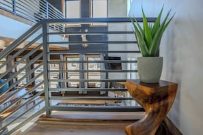 A potted plant on a wooden side table by a metal railing, overlooking a staircase. - 2 Cabins - Indoor Pool & 2 Hot Tubs - Sleeps 13 (Pigeon Forge)