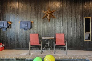 A room with two red chairs, a small round table, a wooden star decoration, and a tiled floor. - 2 Cabins - Indoor Pool & 2 Hot Tubs - Sleeps 13 (Pigeon Forge)