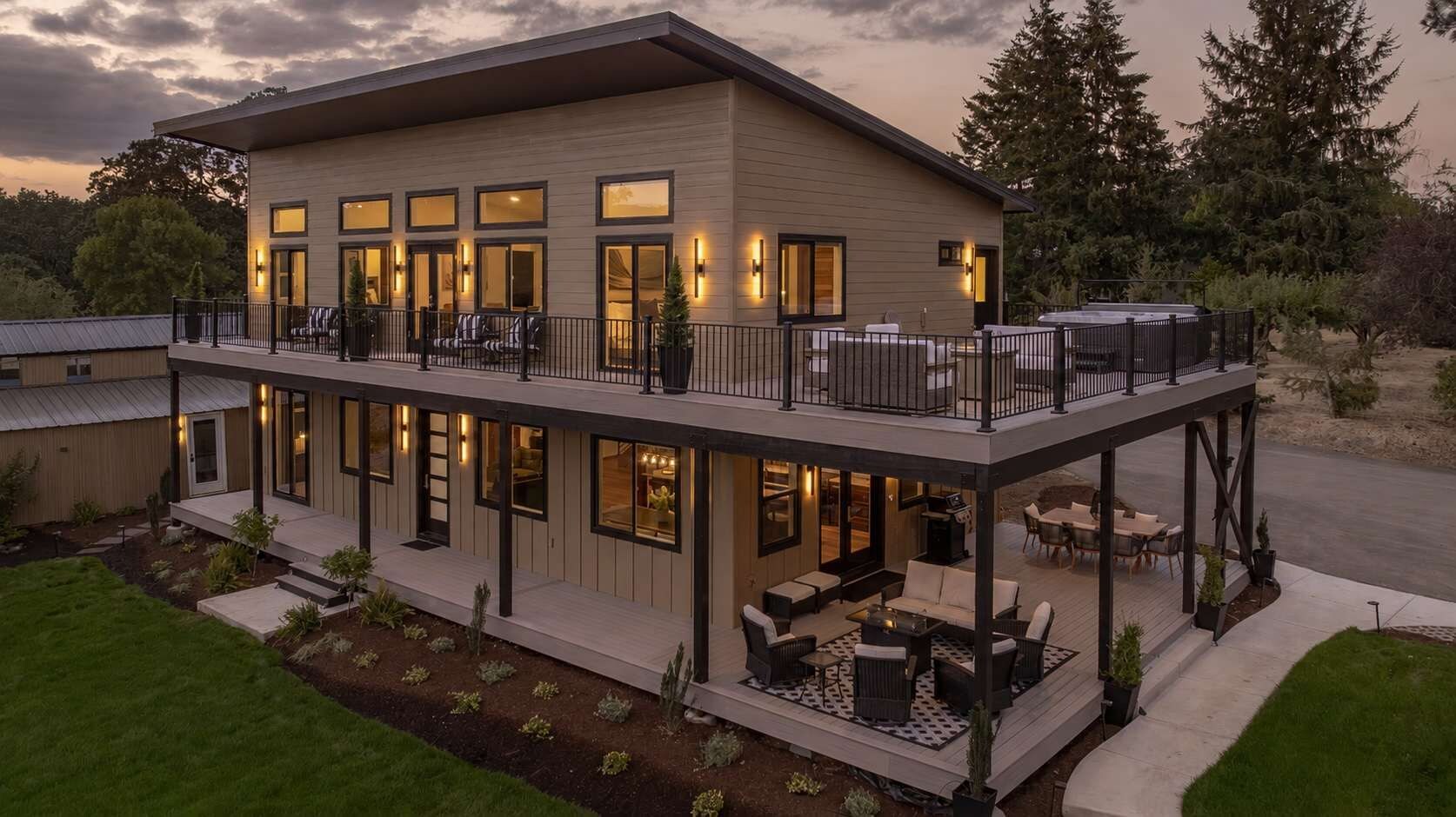 A two-story building with a balcony, outdoor seating, and a well-lit entrance.