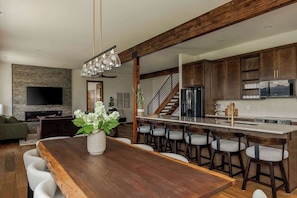 A modern kitchen with a central island, bar stools, and a built-in microwave. - Summers Hill - Newly Built Wine Country Estate (Carlton)