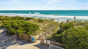 A beach with a wooden fence, a bench, and a sign indicating no parking. - Waterfront Slice of WB Paradise w Dock and Boat Lift! PRIME location! (Wrightsville Beach)