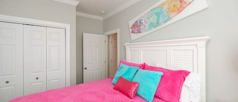 Un dormitorio con cama, cabecera blanca y una obra de arte colgada en la pared.