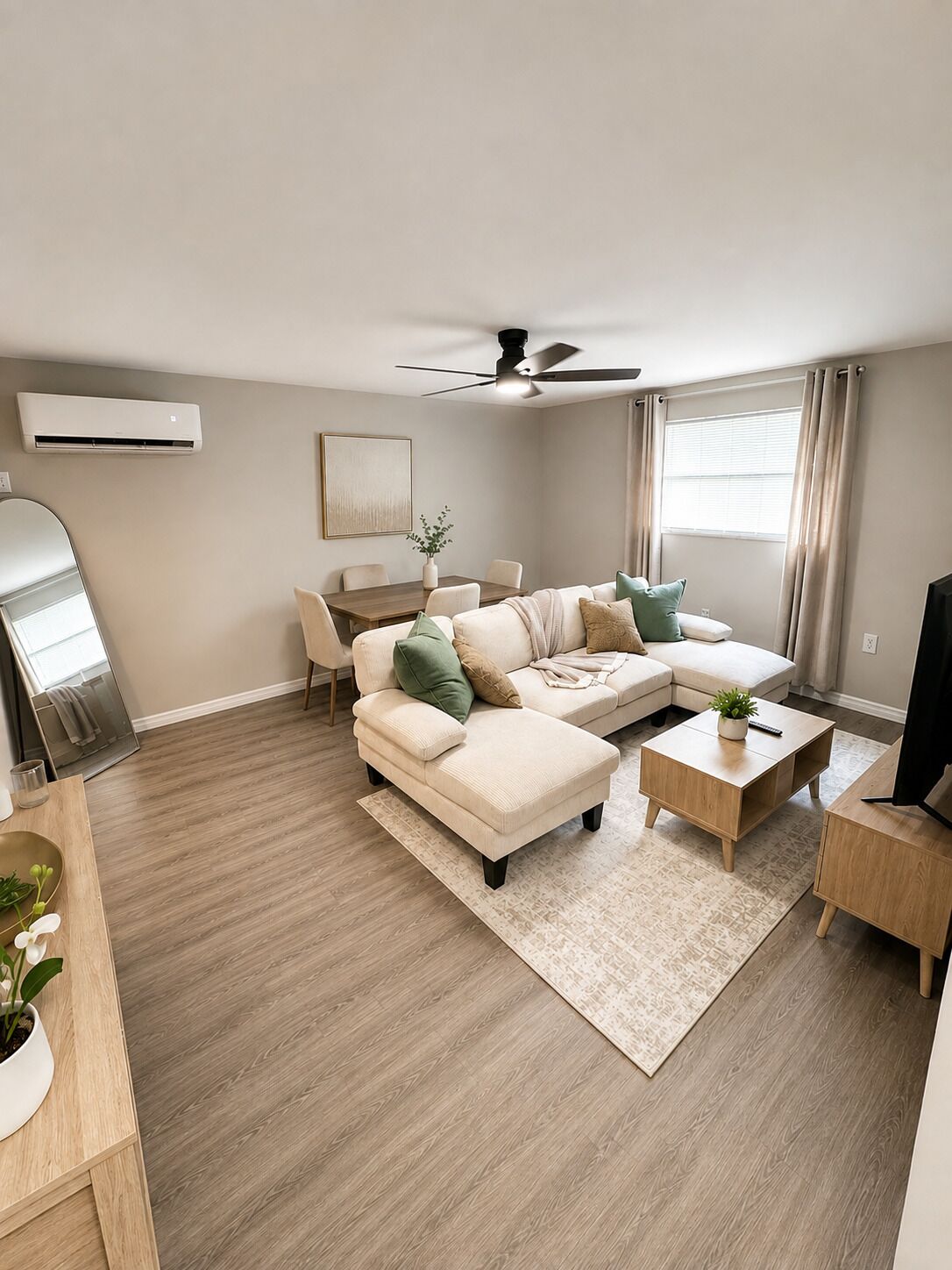 A modern living room with a sectional sofa, a coffee table, and a television stand.