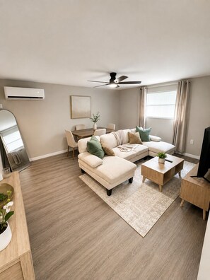 Una sala de estar moderna con un sofá modular, una mesa de centro y un mueble para televisión.