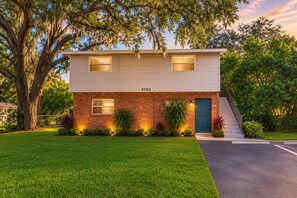 A two-story house with a brick facade, a blue door, and a number '9703' on the front. - Terrific 2-bedroom apartment with AC in sunny Tampa (Tampa)