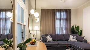A modern living room with a sofa, a mirror, a lamp, and a bowl of fruit. - Quiet Art Deco 2BR Retreat in the Heart of Potts Point (Potts Point)
