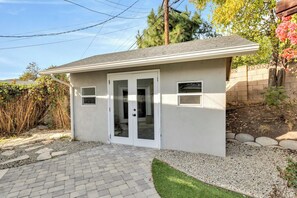 A small single-story building with a garage door, a paved driveway, and a well-maintained lawn.