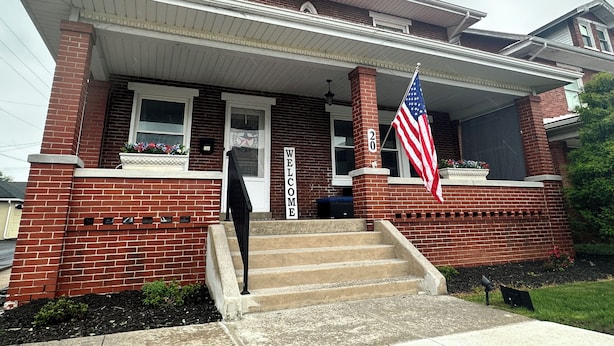 A two-story house with a front porch, a welcome sign, and an American flag. - Hershey Station at the Square No. 1 - Closest Rental to Downtown Square Hershey (Hershey)