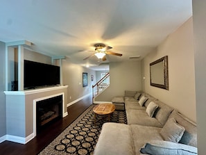 A living room with a television, fireplace, sofa, and patterned rug. - Relaxing Fletcher Townhome with proximity to Asheville and Hendersonville (Fletcher)