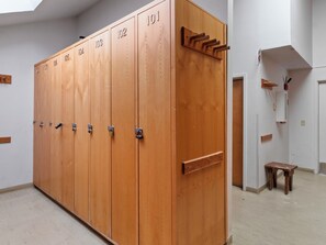 A row of wooden lockers with numbered doors, a small wooden stool, and a wall-mounted rack with hooks. - Snow Flower 56 | Ski-In/Out | Pool | Hot Tub | Parking | Tennis | Pickleball | Park City (Park City)