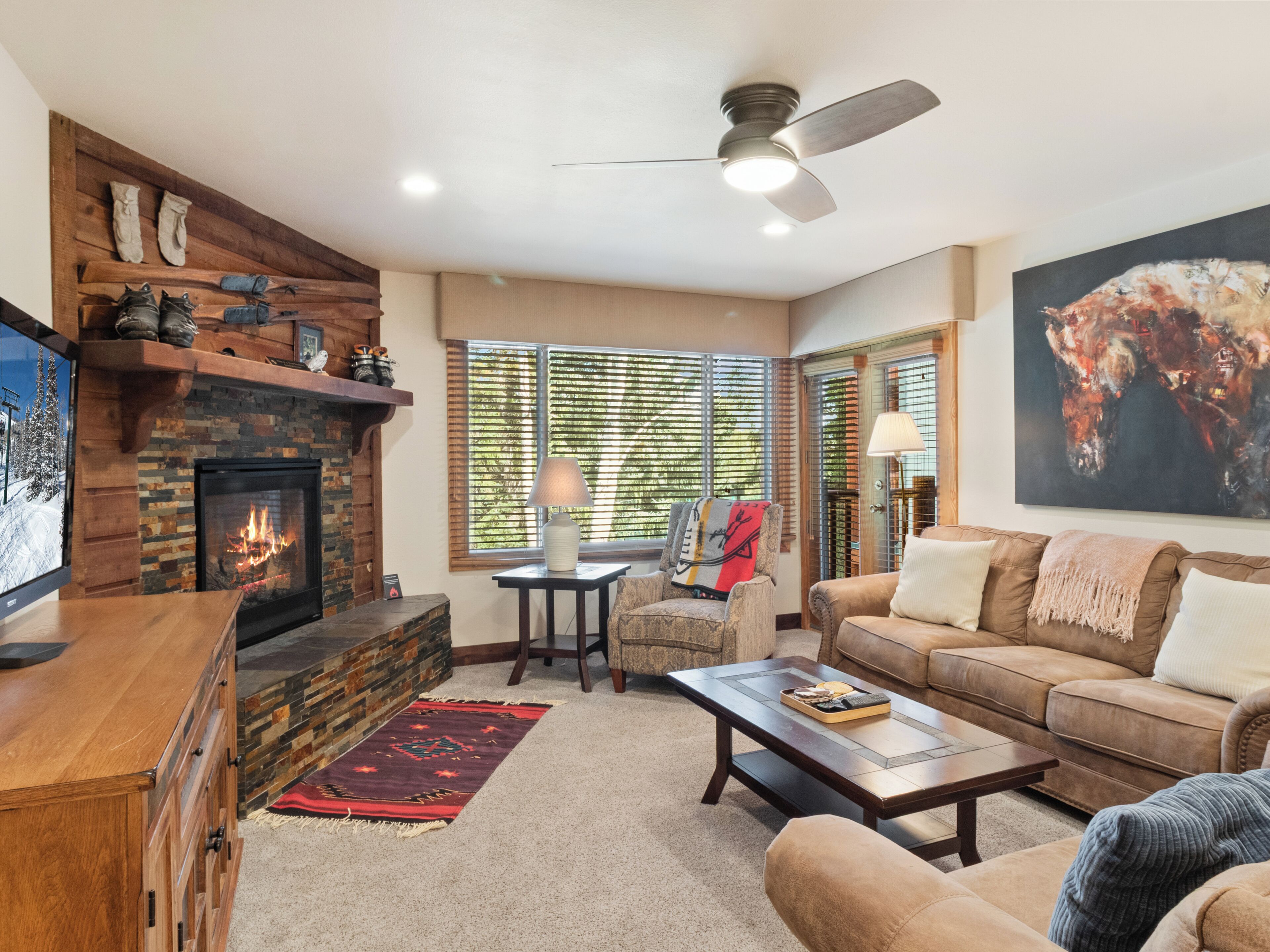 A living room with a fireplace, a sofa, a coffee table, and a television.