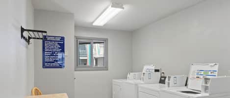 A laundry room with a sign providing instructions, a window, and a counter with a sink.