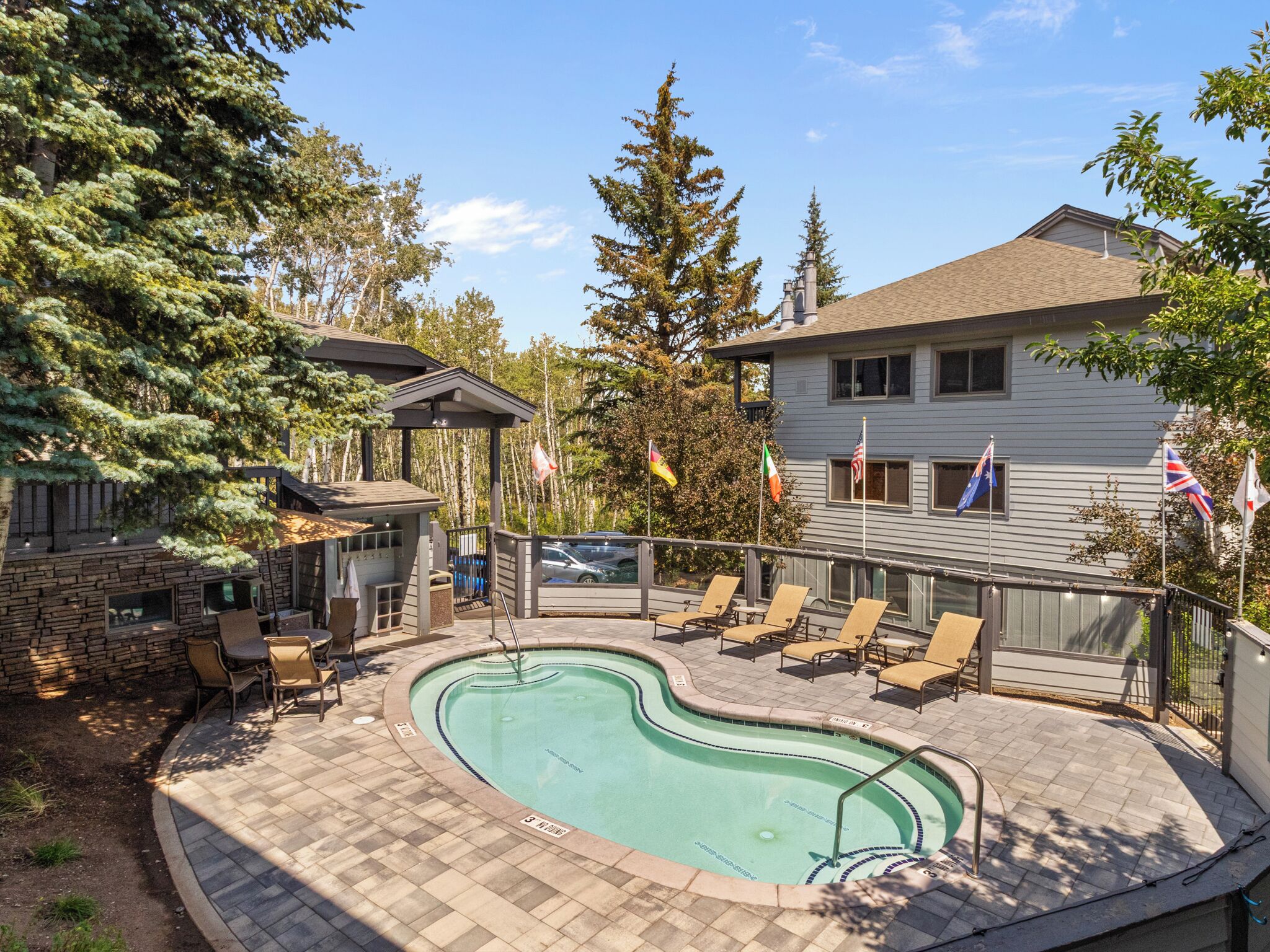 A swimming pool with lounge chairs and a stone patio.