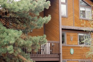 A wooden building with a balcony and a sign with a tree symbol. - Red Pine V6 | Canyons Village | Pools | Hot Tub | Sleeps 8 (Park City)