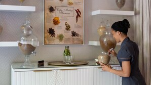 A person at a counter with a spice journal, jars of spices, and a decorative wall. - Mont Rochelle – A Luxurious Escape in Franschhoek, 1028 (Western Cape)