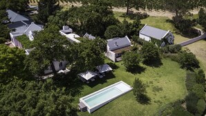 A residential area with multiple houses, a swimming pool, and a vineyard in the background. - Mont Rochelle – A Luxurious Escape in Franschhoek, 1028 (Western Cape)
