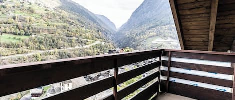 Un balcón con vista a un valle y montañas.