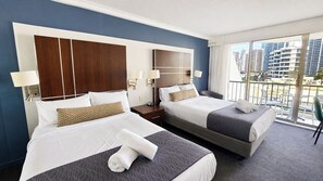 A hotel room with two beds, a large window with a view of the city, and a balcony with outdoor seating. - Cozy 2 Beds Hotel Room丨Beachside丨Max 4 guests (Surfers Paradise)