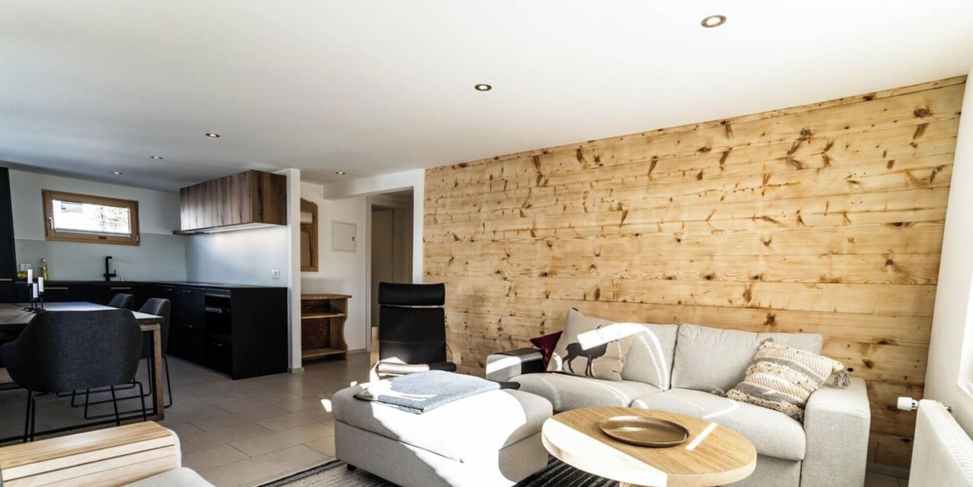 A modern living space with a kitchen, dining area, and a sofa set.