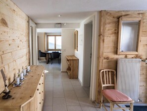 A wooden interior with a long table, chairs, a radiator, and a window. - Your Perfect Mountain Stay, Wallis 1064 (Wallis)