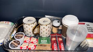 A tray with various items including coffee mugs, coffee cups, and coffee pods.
