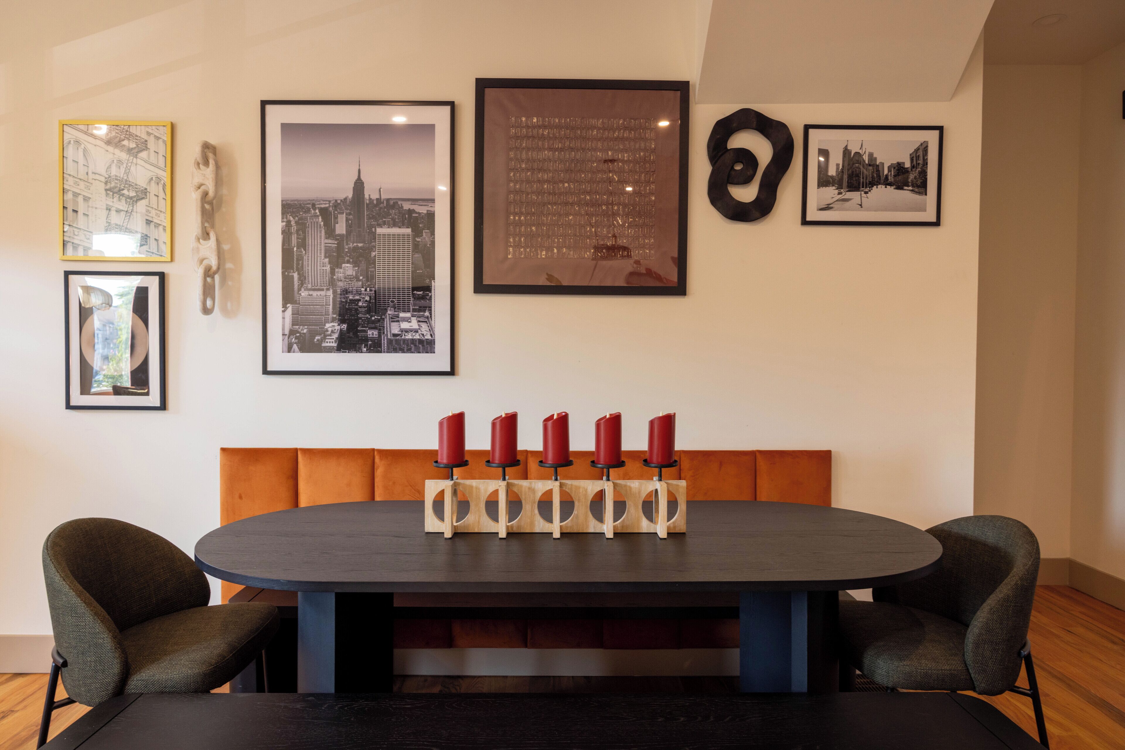 Comedor con una mesa redonda, cuatro sillas y un candelabro con velas rojas.