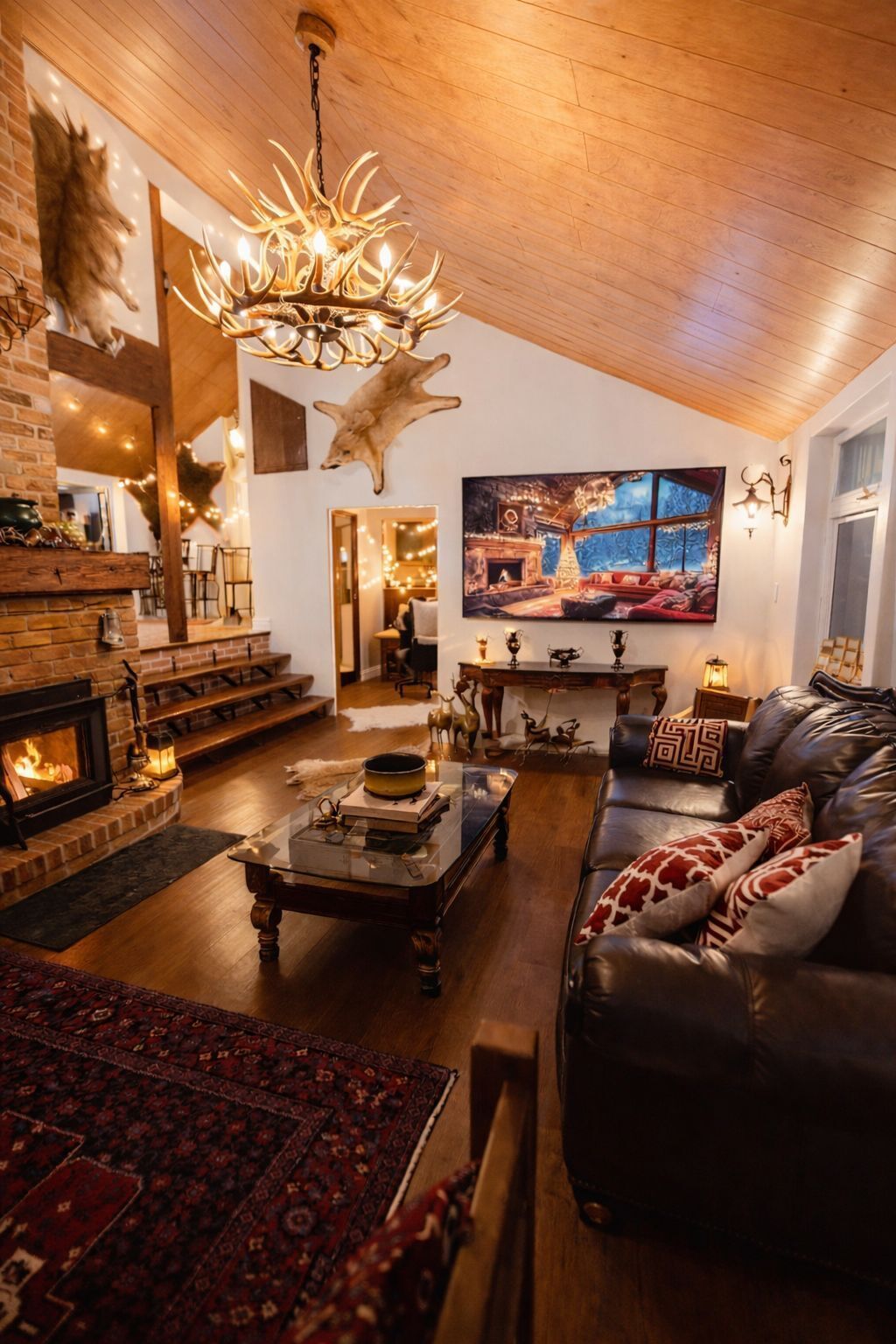 A cozy living room with a fireplace, leather sofa, and a large television.