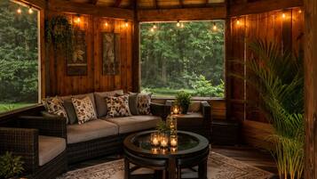 A cozy, wooden interior with a sofa, round coffee table, and potted plants.